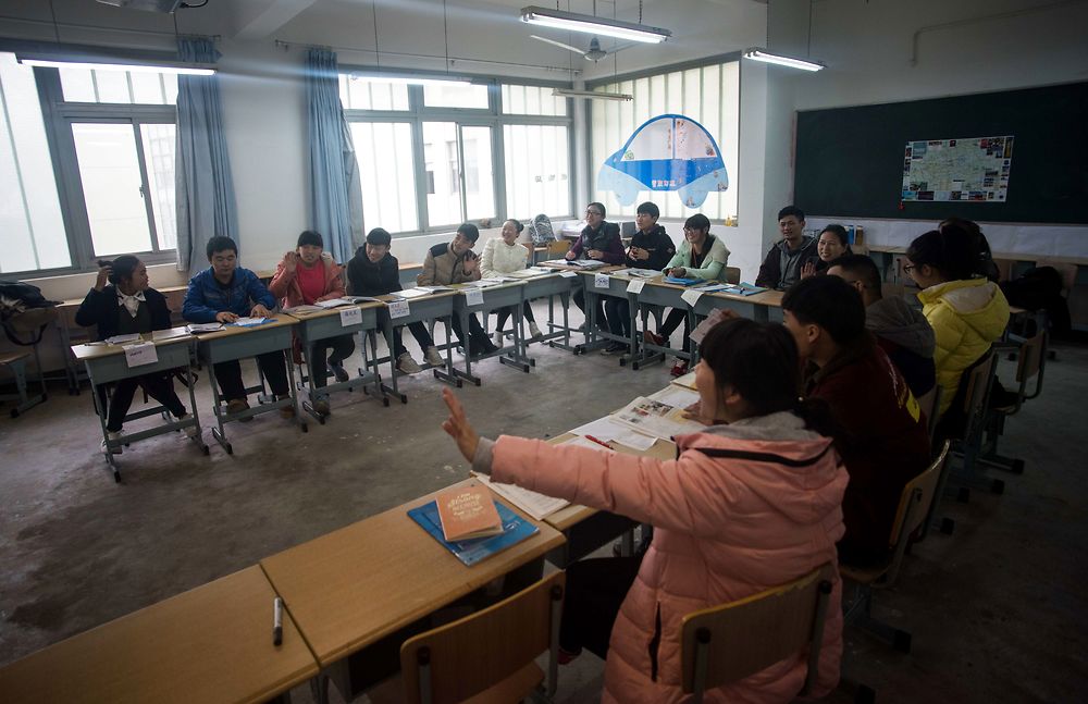 This picture taken on December 11, 2015 shows students of the Shanghai Young Bakers attending an English class at the Caoyang Vocational School in Shanghai. The Shanghai Young Bakers NGO offers a one year vocational training course for Chinese youth who have family difficulties resulting in them having to drop out of school because of financial problems or parental health issues. This year's 31 students who come from all over China are trained in French baking as well as English language skills. The students spend one week in school and the other week as an intern in different international hotels in Shanghai. AFP PHOTO / JOHANNES EISELE