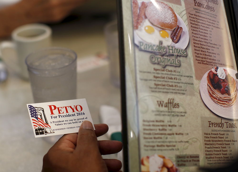 A customer at a restaurant holds a card given to him by U.S. Republican presidential candidate Michael Petyo in Portage, Indiana, United States, December 6, 2015. Reuters Photographer Jim Young: "Hillary and Donald are running. So are more than 1, 500 others, among them Michael Petyo of Hobart, Indiana. He's not a household name, nor does he have millions of dollars in backing. Petyo is a building contractor, a father and a U.S. Navy veteran. Back in May, Petyo handed me his card. He was outside an event in Des Moines, Iowa, attended by leading potential Republican candidates. Petyo said the party wouldn't let him inside. We only spoke for a minute. Months later, I read of a few hundred people having already signed up to run for president: businesspeople, teachers, bartenders. Petyo lives about 75 miles from me so I arranged to meet. We spoke for a couple of hours at his dinner table with his wife. This is my fourth presidential election campaign. I have logged countless miles and been to hundreds of events - but always with candidates with massive financial backing and support from countless volunteers. Petyo has business cards, his van, his beliefs. He speaks about the working class, faith, the military. In his spare time he bakes to raise money for the church. Religion is important to him and he speaks about it passionately. Over the months we meet up while he campaigns and goes about his life. Petyo drives to a Republican debate in Milwaukee in November; the door is shut there too. He still works the lines of attendees outside. In Chicago people brush by on a cold, windy day as he tries to introduce himself. Some stop to ask him about his policies. He is not a full-time politician, just a regular guy facing what many would call insurmountable obstacles. It's quite the understatement to say the odds are stacked against him. But that shouldn't stop him or anyone from trying." REUTERS/Jim Young SEARCH "PETYO" FOR ALL IMAGES