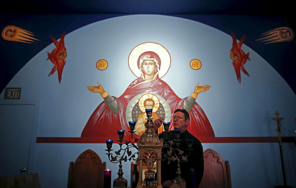 U.S. Republican presidential candidate Michael Petyo lights candles before the start of a reader service at Saint Nicholas Orthodox Church where he is a Cantor in Hobart, Indiana, United States, December 6, 2015. Reuters Photographer Jim Young: "Hillary and Donald are running. So are more than 1, 500 others, among them Michael Petyo of Hobart, Indiana. He's not a household name, nor does he have millions of dollars in backing. Petyo is a building contractor, a father and a U.S. Navy veteran. Back in May, Petyo handed me his card. He was outside an event in Des Moines, Iowa, attended by leading potential Republican candidates. Petyo said the party wouldn't let him inside. We only spoke for a minute. Months later, I read of a few hundred people having already signed up to run for president: businesspeople, teachers, bartenders. Petyo lives about 75 miles from me so I arranged to meet. We spoke for a couple of hours at his dinner table with his wife. This is my fourth presidential election campaign. I have logged countless miles and been to hundreds of events - but always with candidates with massive financial backing and support from countless volunteers. Petyo has business cards, his van, his beliefs. He speaks about the working class, faith, the military. Religion is important to him and he speaks about it passionately. Over the months we meet up while he campaigns and goes about his life. Petyo drives to a Republican debate in Milwaukee in November; the door is shut there too. He still works the lines of attendees outside. In Chicago people brush by on a cold, windy day as he tries to introduce himself. Some stop to ask him about his policies. He is not a full-time politician, just a regular guy facing what many would call insurmountable obstacles. It's quite the understatement to say the odds are stacked against him. But that shouldn't stop him or anyone from trying." REUTERS/Jim Young SEARCH "PETYO" FOR ALL IMAGES