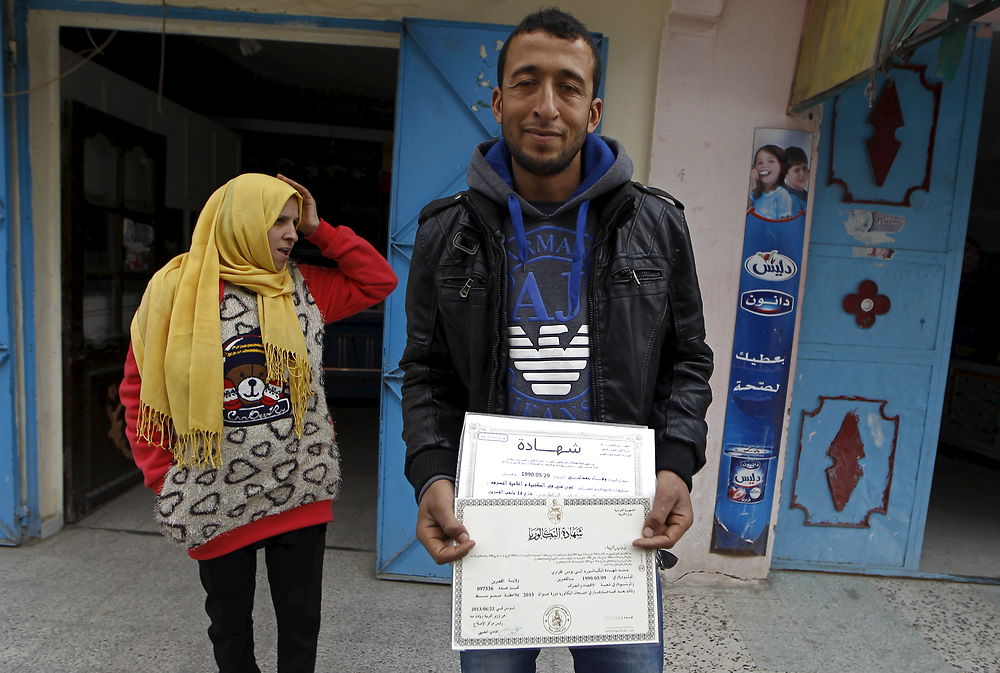 Younes Fekraoui, 26 år, nyuddannet og arbejdsløs, står med sit eksamensbevis.