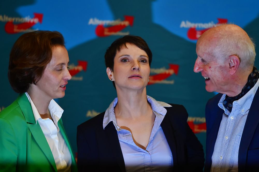 CORRECTION - (L-R) Beatrix von Storch, Frauke Petry and Albrecht Glaser of the right-wing populist party Alternative for Germany (AfD) party react after state elections exit poll results were announced on tv in Berlin on March 13, 2016. Chancellor Angela Merkel's party received a drubbing at key state elections in Saxony-Anhalt, Baden Wuerttemberg and Rheinland-Pfalz on March 13, 2016 as voters punish the German leader for her liberal refugee policy, while the right-wing populist AfD make major gains as it scoops up the protest vote. / AFP PHOTO / John MACDOUGALL / "The erroneous mention[s] appearing in the metadata of this photo by John MACDOUGALL has been modified in AFP systems in the following manner: [Albrecht Glaser] instead of [Ronald Glaeser]. Please immediately remove the erroneous mention[s] from all your online services and delete it (them) from your servers. If you have been authorized by AFP to distribute it (them) to third parties, please ensure that the same actions are carried out by them. Failure to promptly comply with these instructions will entail liability on your part for any continued or post notification usage. Therefore we thank you very much for all your attention and prompt action. We are sorry for the inconvenience this notification may cause and remain at your disposal for any further information you may require."