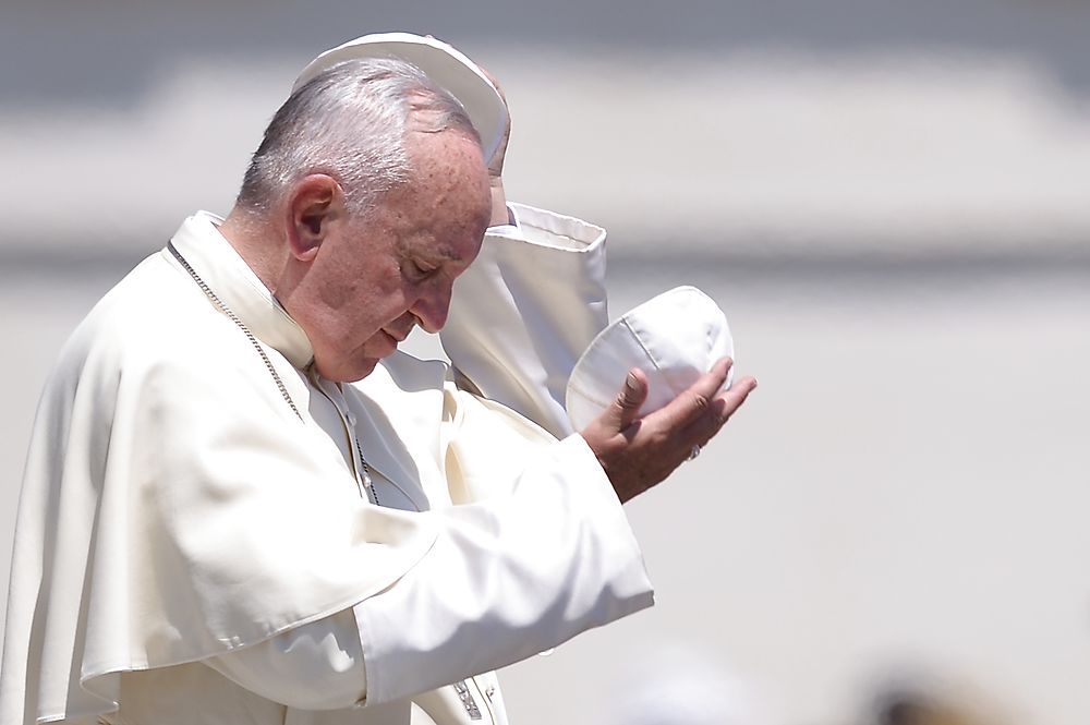 TOPSHOTS Pope Francis exchanges his skull cap with a little girl (not seen) during his weekly general audience at St Peter's square on June 10, 2015 at the Vatican. AFP PHOTO / FILIPPO MONTEFORTE