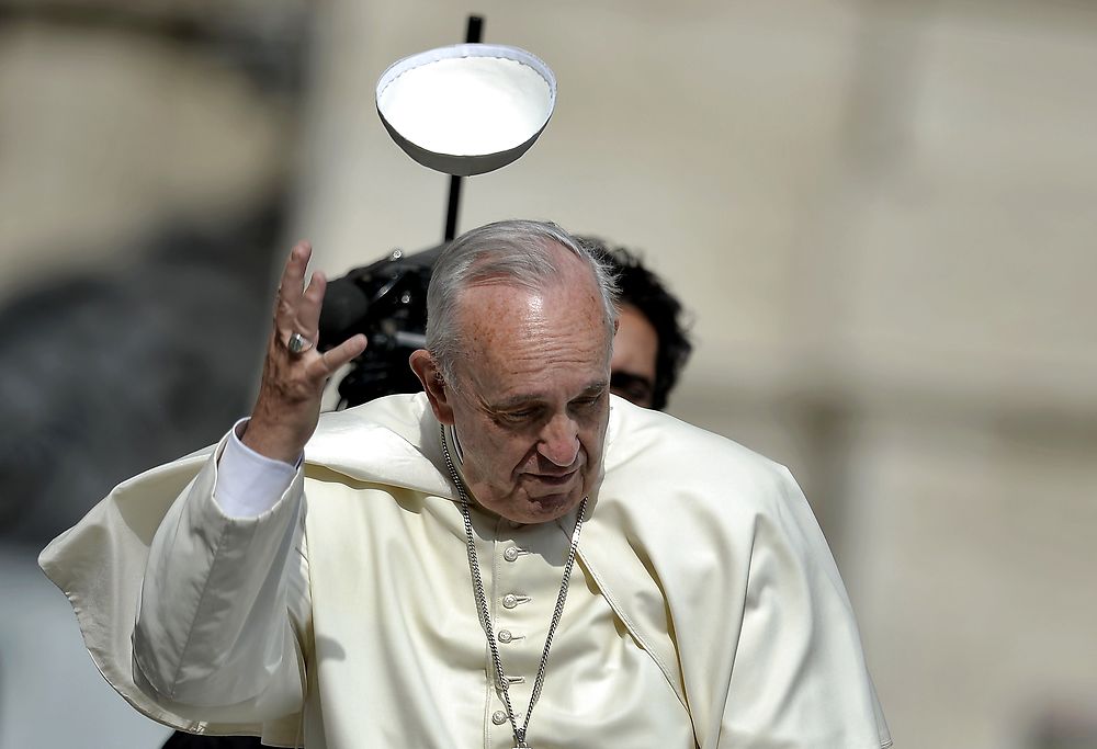 TOPSHOTS A gust of wind blows away Pope Francis' skullcap as he arrives to lead the weekly audience atSaint Peter's Square in the Vatican on June 24, 2015. AFP PHOTO / FILIPPO MONTEFORTE