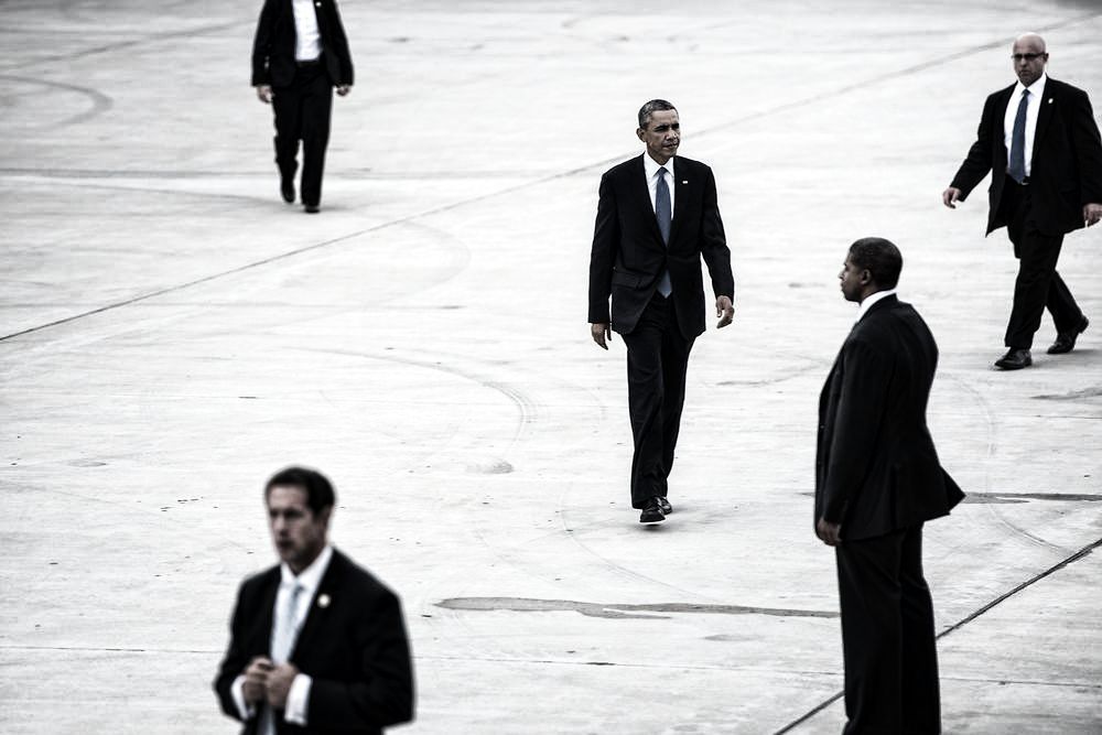 TOPSHOTS Members of the US Secret Service escort US President Barack Obama as he walks to Air Force One at Gary Chicago International Airport on October 2, 2014 in Gary, Indiana. Obama is returning to Washington after a trip to Illinois where he attended a fundraiser and spoke about the economy. AFP PHOTO/Brendan SMIALOWSKI