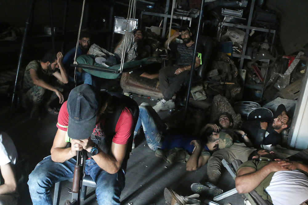 Free Syrian Army fighters rest inside a mechanic shop in Ramousah area southwest of Aleppo, Syria August 2, 2016. Picture taken August 2, 2016. REUTERS/Abdalrhman Ismail